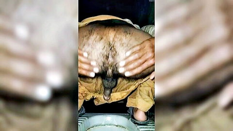Dark-skinned Indian man squatting spreading hairy asshole with hands exposing anus closeup