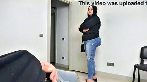 Shocked Muslim woman in hoodie and tight jeans reacts in public waiting room