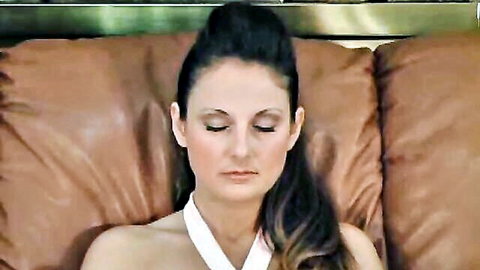 Lola Lynn lounging seductively on couch in white halter top, eyes closed