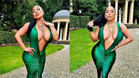 Seductive curvy Latina in revealing green dress posing outdoors