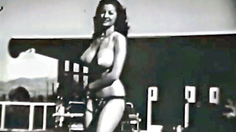 Vintage busty brunette posing topless in bikini bottom by pool