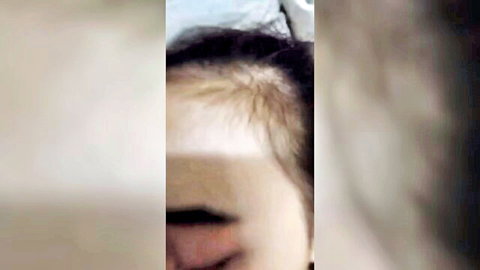 Blurry close-up of Asian woman's face in adult video thumbnail, neutral expression