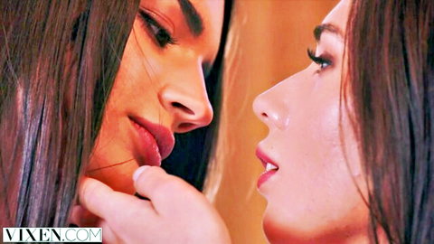 Two sexy brunettes with plump lips leaning in for a passionate lesbian kiss