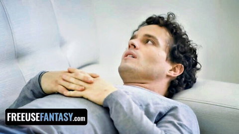 Curly-haired man lying ecstatic on white couch in gray shirt freeuse fantasy tease