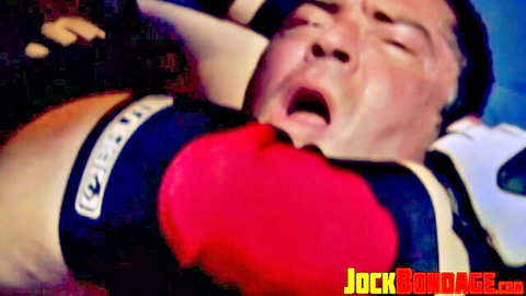 Muscular Asian jock in boxing gloves and blue bondage straps with mouth wide open in intense gay BDSM ecstasy.