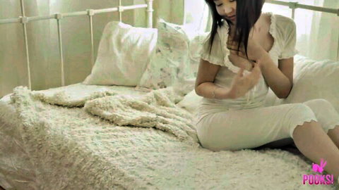 Asian beauty in white lingerie teasing on bed, solo sensual moment