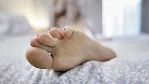 Close-up of sexy bare female feet with painted toenails, teasing soles