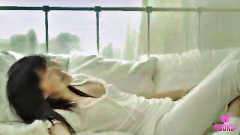 Fen lounging seductively on bed in sheer white top and pants