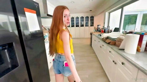 Skinny redhead teen in tiny denim shorts and yellow tank top teasing ass in modern kitchen
