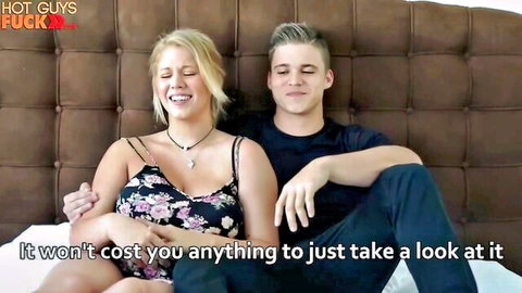 Kyle Dean and smiling blonde in floral dress teasing on bed
