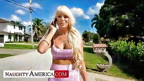 Busty blonde in skimpy pink bikini with massive tits talks on phone walking sunny street