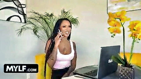 Smiling ebony MYLF in white tank top on steamy phone call