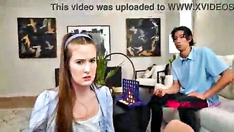 Step sis in blouse sits with bully on couch during game setup