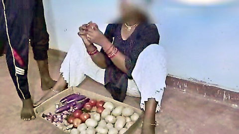 Indian vegetable seller in traditional attire sits with produce, blurred face