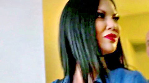 Jasmine Jae seductive profile with long black hair, red lips, blue top