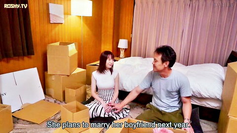 Young Japanese woman in skirt chats intimately with older man among boxes