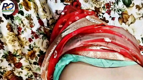 Indian Bhabhi in red saree exposing midriff and green panties on bed