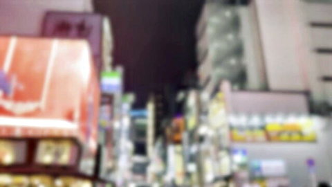 Blurry neon-lit Tokyo street at night with vibrant pink and purple city lights