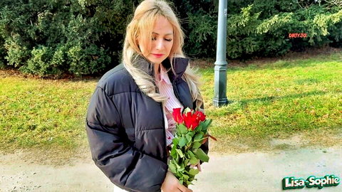Blonde Lisa-Sophie in puffer jacket holding red Valentine's roses outdoors
