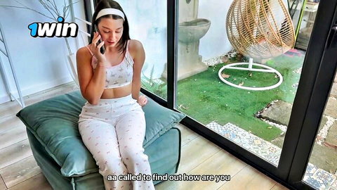 Brunette in white crop top and pants talking on phone, teasing vibe