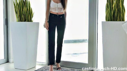 Slim Asian beauty in lace bralette and tight black pants posing indoors