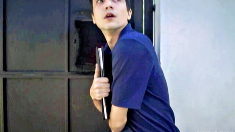 Surprised Asian guy in blue polo peeks with laptop, bullying revenge scene