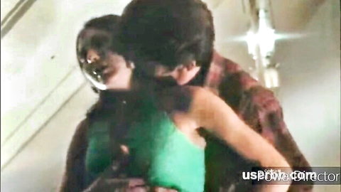 Passionate kiss between dark-haired couple, woman in green top