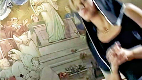 Blonde woman in black top poses intensely before biblical painting in Mac Beth porn parody