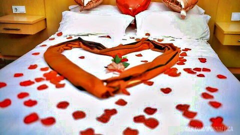 Romantic bedroom with heart-shaped towel, rose petals, and balloons for intimate niece encounter