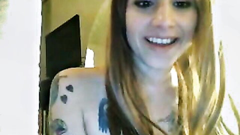Smiling tattooed blonde girlfriend showing upper body tattoos