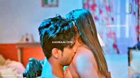 Indian man passionately kissing topless South Asian woman's bare neck and tits on bed