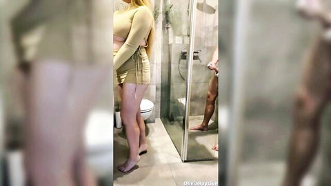 Blonde big ass babe in tight outfit watches naked man showering with visible cock