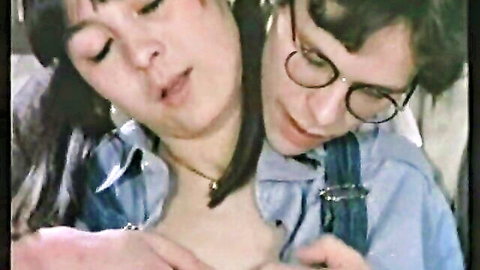Vintage mature brunette woman with open mouth passionately necking glasses guy in denim shirt and suspenders