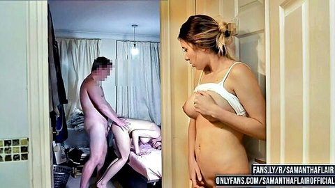 Brunette babe exposing perky tits in doorway beside nude stud fucking her doggy style on bed