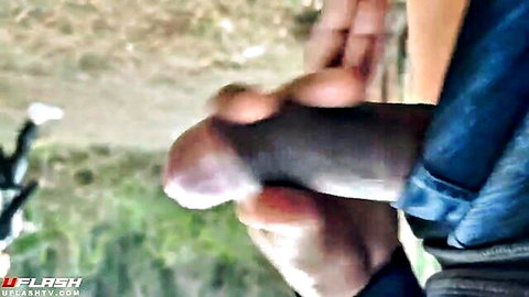 Man masturbating erect penis outdoors in front of watching girl