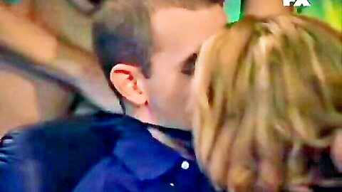 Blonde woman passionately kissing man in candid TV tease scene