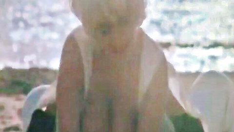 Debora topless in wet towel on beach from Paprika 1991 erotic scene