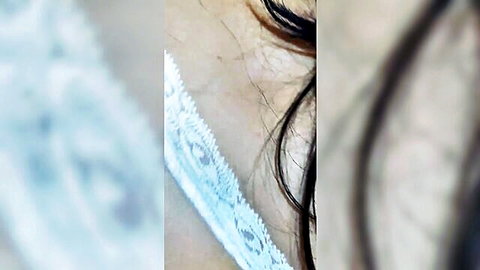 Blurry closeup of brunette's eye lashes skin and white lace lingerie details
