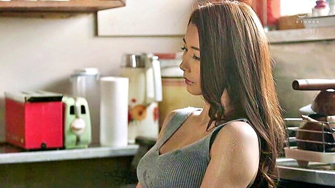 Sexy East Asian brunette with big tits in low-cut gray tank top leaning over kitchen counter