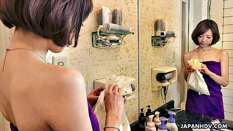 Petite Japanese babe with bare back and sideboob holds towel in bathroom mirror reflection