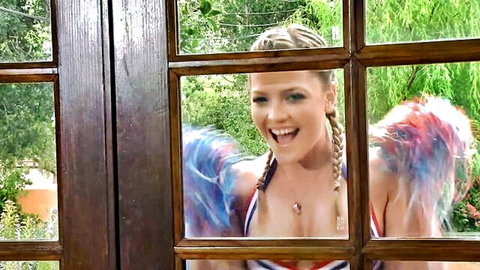 Blonde babe with big tits in feathered wings and skimpy bikini smiling excitedly through window