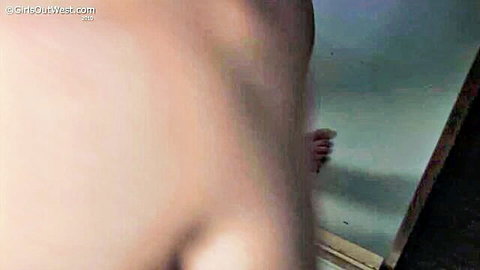 Young skinny brunette's wet hand spreads teasingly on steamy shower mirror