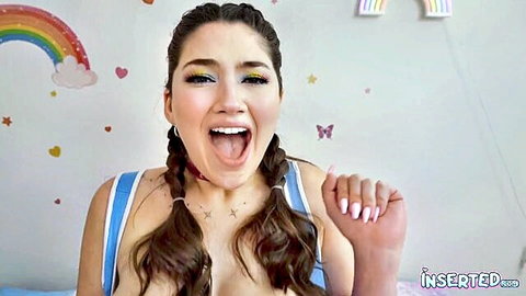 Alyx Star smiling naughtily in pigtails and blue top