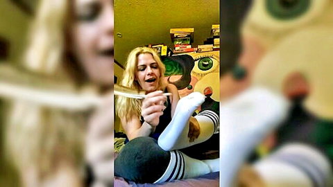 Blonde in striped knee socks tickles sexy foot with feather in foot fetish tease