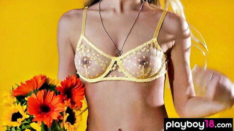 Blonde babe in sheer yellow daisy bra exposing big tits and nipples holding flowers