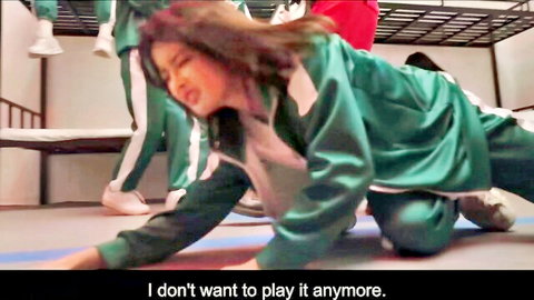 Asian women in Squid Game green tracksuits, one distressed on floor begging to quit