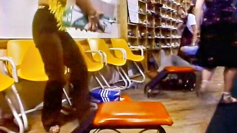 Sexy retro women in tight clothes posing and bending in vintage shoe store classroom with yellow chairs