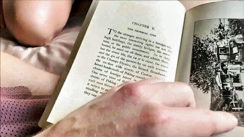 Hands holding open book page to Chapter V The Stranger with smuggling text visible