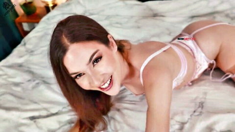 Smiling young brunette in pink lingerie teases ass on bed POV