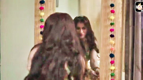 Desi Indian wife in green saree gazing in mirror, long wavy hair
